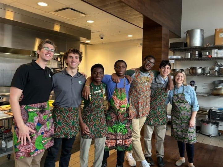 students in kitchen wearing aprons